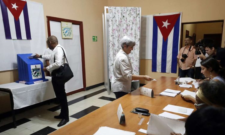 Dos personas votan en las elecciones parlamentarias, en un colegio electoral de La Habana, el domingo 26 de marzo de 2023. Foto: Ernesto Mastrascusa / EFE.