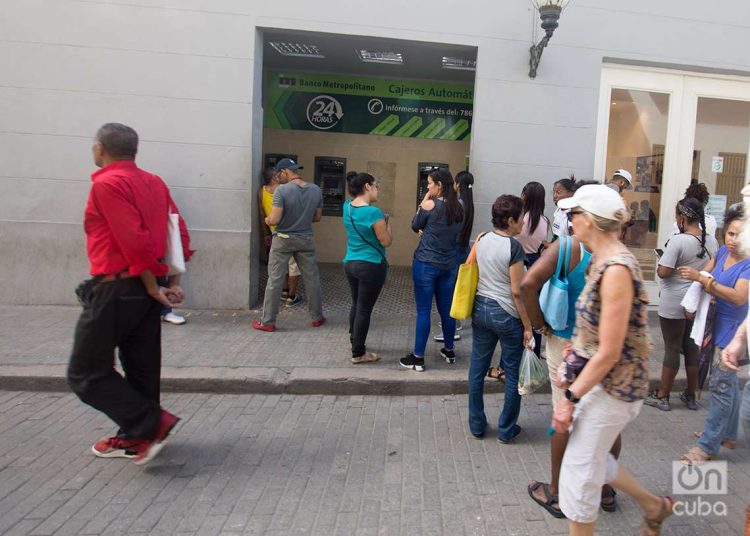 Personas hacen cola para usar cajeros electrónicos, en La Habana. Foto: Otmaro Rodríguez.