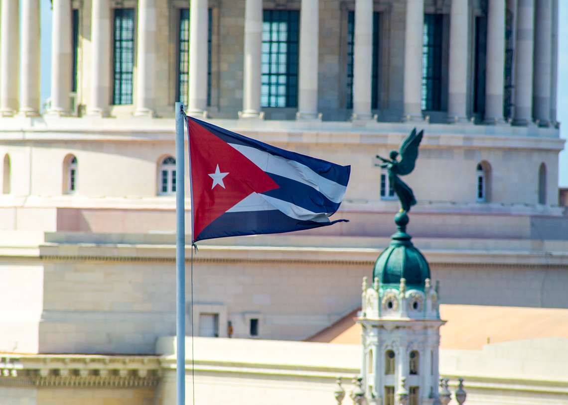 Bandera cubana y ángel en una cupulina del Gran Teatro de La Habana. Detrás, cúpula del Capitolio Nacional. Foto: Otmaro Rodríguez.