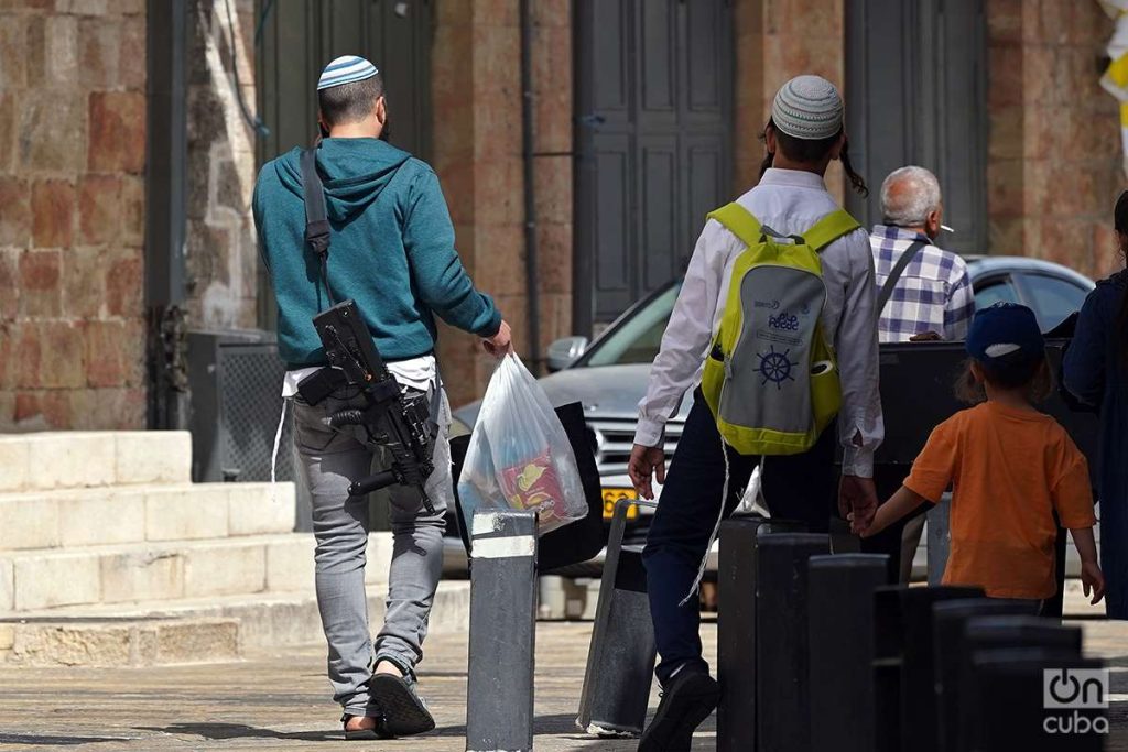 Un colono judío camina portando un rifle de asalto por el Barrio Cristiano de la Ciudad Vieja de Jerusalén. Foto: Alejandro Ernesto.