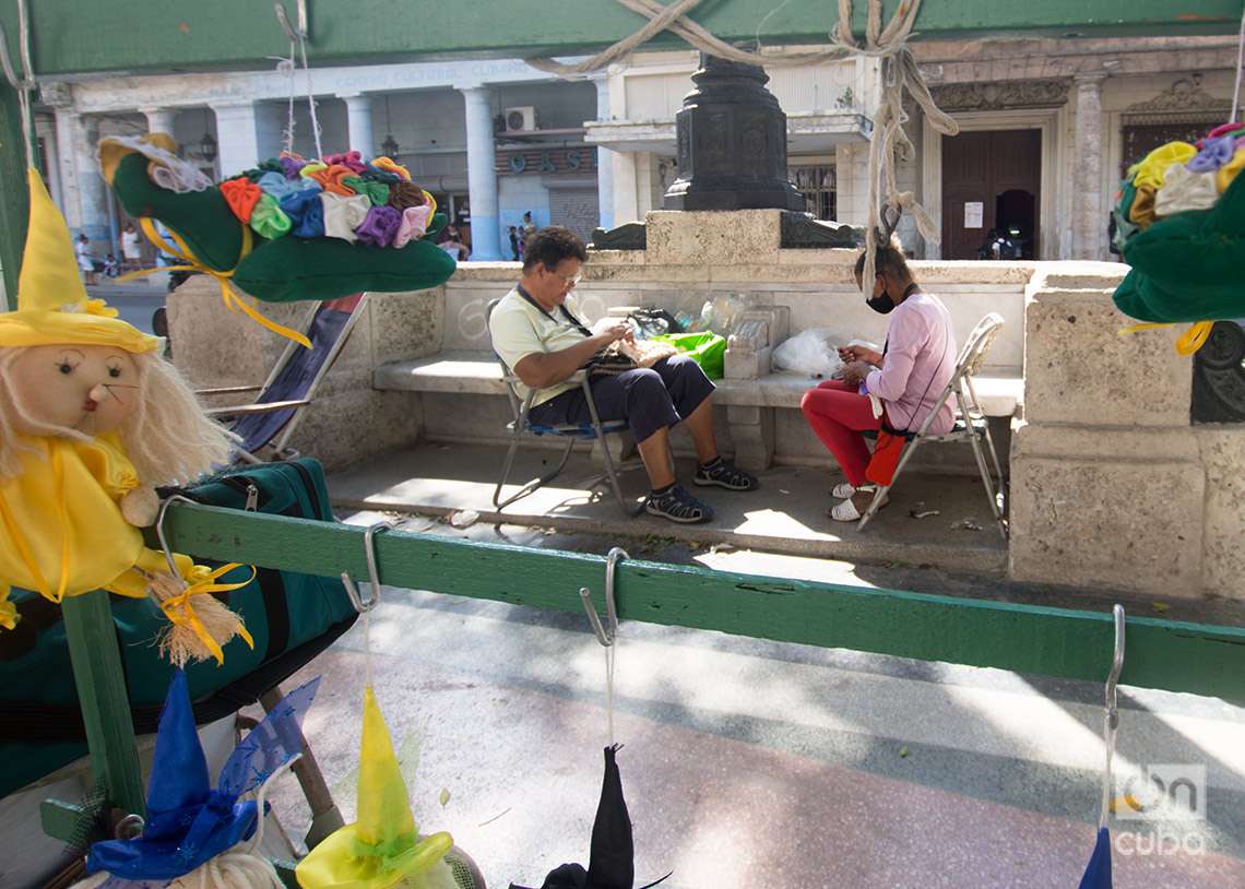 Dos mujeres realizan trabajos artesanales en el Paseo del Prado, en La Habana, para su venta en el lugar. Foto: Otmaro Rodríguez.