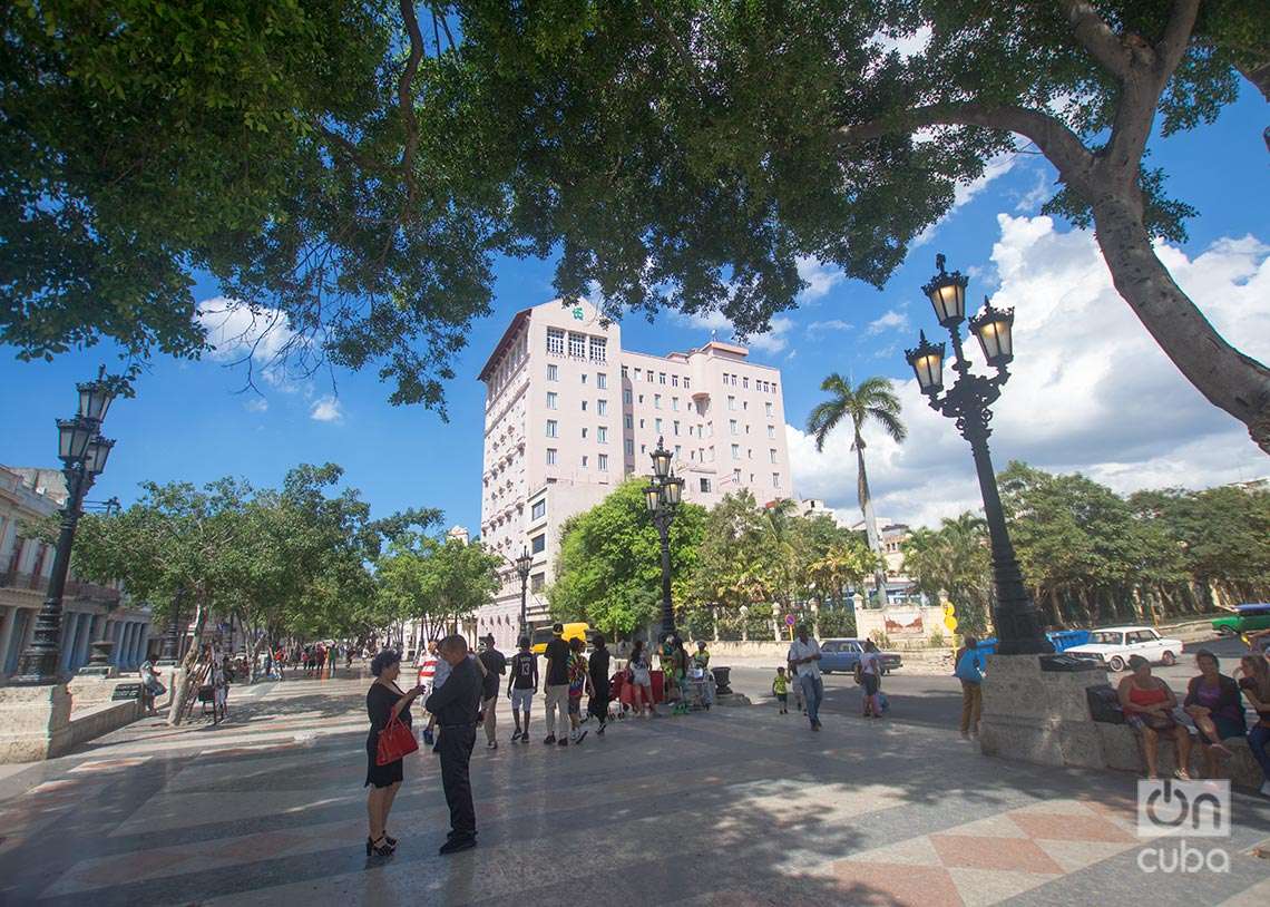 Personas en Paseo del Prado, en La Habana, Detrás, el Hotel Sevilla, fundado en 1908. Foto: Otmaro Rodríguez.