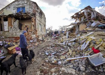 Un hombre de 49 años, Guenadi,  muestra el edificio destruido de sus vecinos en Cherkaski Tyshky, región de Kharkiv, Ucrania, el 27 de marzo de 2023. El ejército ucraniano expulsó a las fuerzas rusas del territorio ocupado al noreste del país en contraataques en el otoño de 2022. Kharkiv y sus alrededores Las zonas han sido objeto de intensos bombardeos desde febrero de 2022. Foto: EFE/EPA/SERGEY KOZLOV.