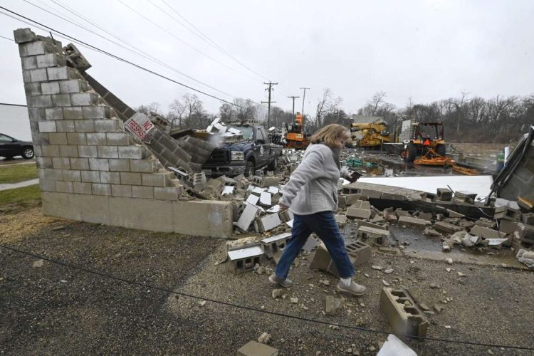 Una mujer pasa frente a un negocio destruido luego de un tornado en Belvidere, Illinois, Estados Unidos, el 1 de abril de 2023. Foto: Matt Marton / EFE.