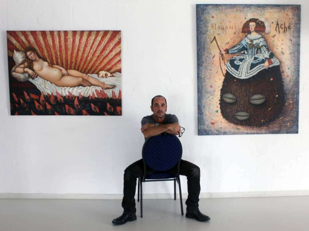 Eduardo Abela junto a obras de una expo anterior. Foto: Cortesía del artista.