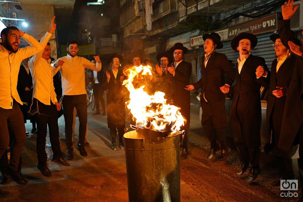 Un grupo de jóvenes baila alrededor de un pequeño fuego en la calle principal de Mea Shearim. Foto: Alejandro Ernesto.