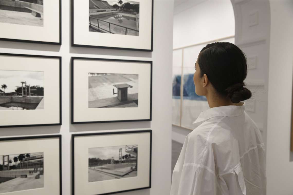 Cuban artist Rachel Valdés observes works from her show "Swimming pools", in the La Cometa gallery, in Madrid.  Photo: Alejandro López / EFE.