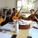 Fotografía cedida por Gibson donde aparecen unos estudiantes de composición de canciones de la Escuela Nacional de Arte (ENA) de Cuba mientras tocan sus nuevas guitarras acústicas Epiphone recibidas de Gibson Gives. Foto: EFE/Gibson.