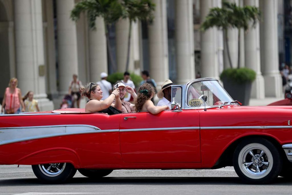 Turistas pasean en un auto clásico en La Habana. Foto: Yander Zamora / EFE.