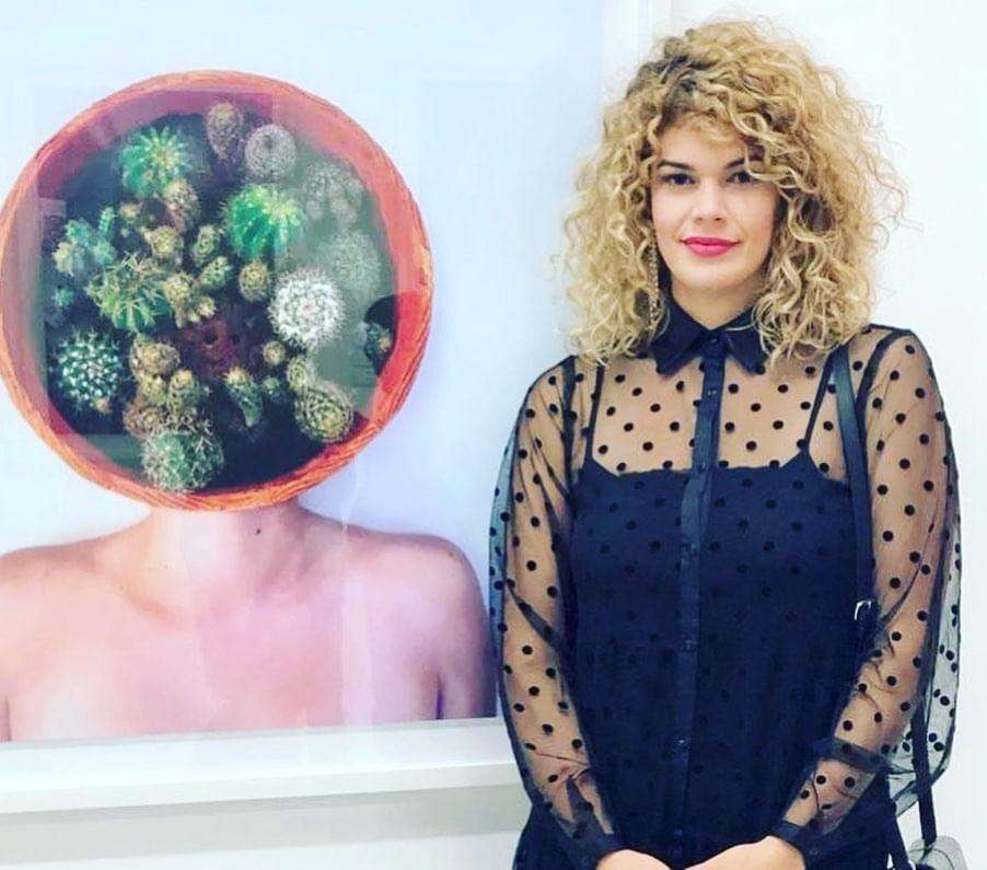 La artista junto a la obra “Aura”, 2019. Impresión digital sobre papel fotográfico, 80 x 80 cm. Foto cortesía de la entrevistada.
