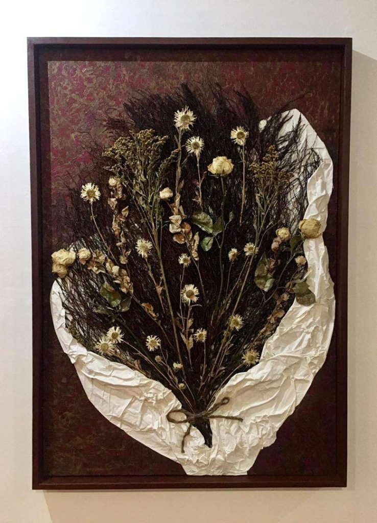  “Regalo”, 2022. Acrílico, papel manufacturado, papel industrial, raíces, flores secas y tiras de yute sobre lienzo, 130 x 90 cm.