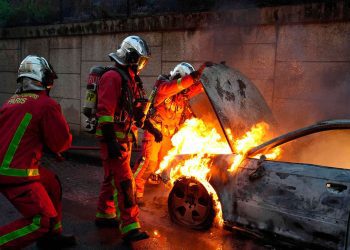 Los bomberos sofocan las llamas de un auto incendiado en los disturbios de Francia. Foto: AFP.