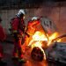 Los bomberos sofocan las llamas de un auto incendiado en los disturbios de Francia. Foto: AFP.