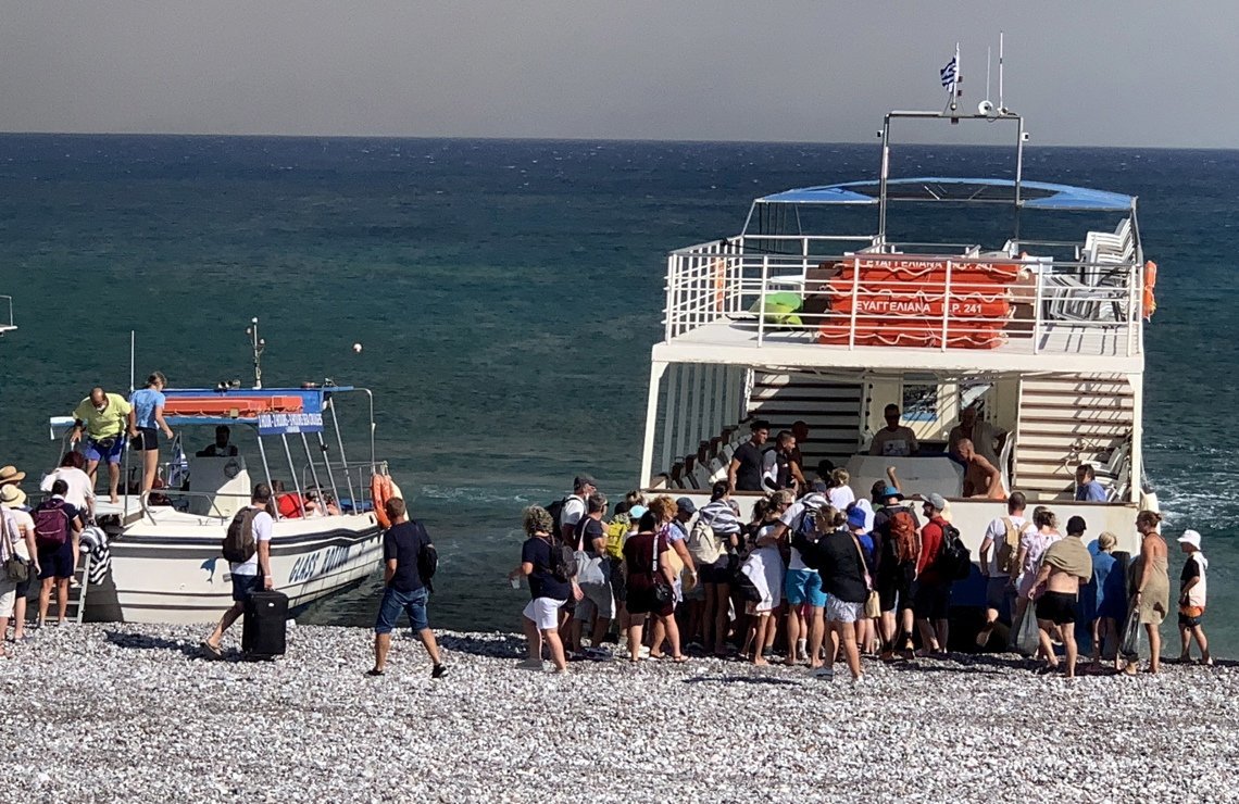 Personas son evacuadas en barcos como consecuencia del incendio fuera de control que afecta a la isla griega de Rodas. Foto: Damianidis Lefteris / EFE.