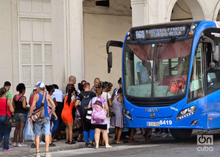 Personas hacen cola para subir a un ómnibus que cubre la ruta entre el reparto Guiteras y el poblado de Regla, y pasa por difrentes zonas de La Habana. Foto: Otmaro Rodríguez.