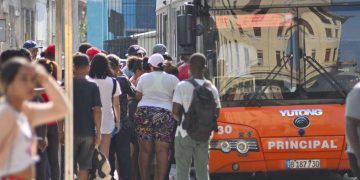 Un grupo de personas hace cola para subir a ómnibus urbano en La Habana. Foto: Otmaro Rodríguez.