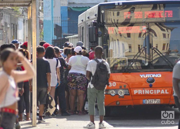 Un grupo de personas hace cola para subir a ómnibus urbano en La Habana. Foto: Otmaro Rodríguez.