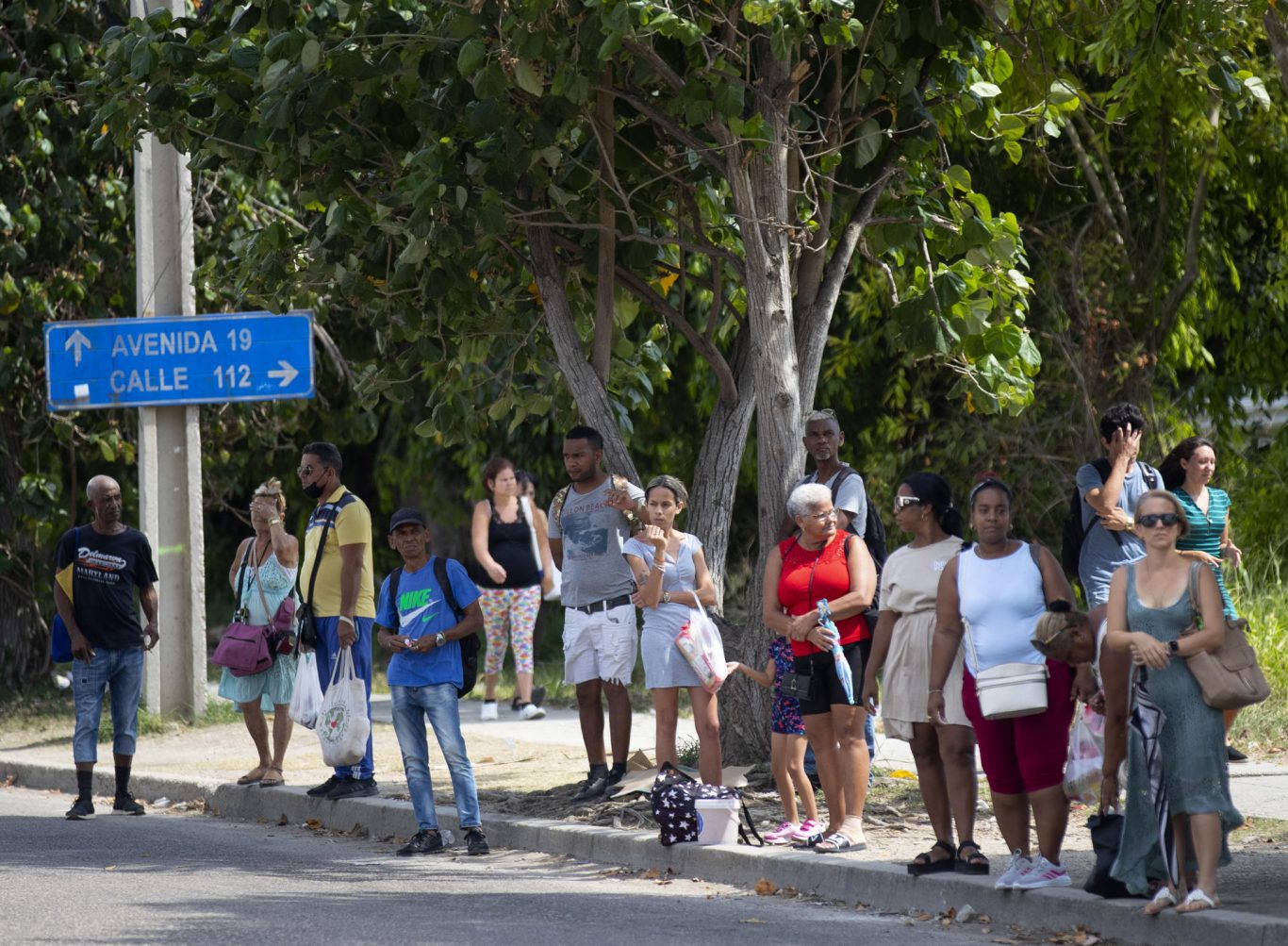 Varias personas esperan una guagua a la sombra, en La Habana. Foto:  EFE/ Yander Zamora.