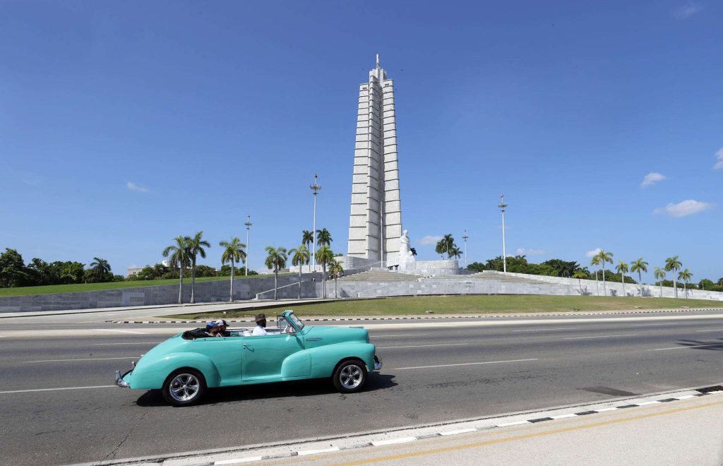 Un auto clásico con turistas pasa frente a la Plaza de la Revolución, en La Habana. Foto: Ernesto Mastrascusa / EFE / Archivo.
