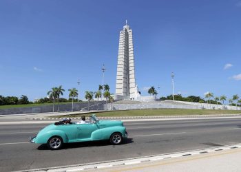 Un auto clásico con turistas pasa frente a la Plaza de la Revolución, La Habana, julio de 2023. Foto: EFE/Ernesto Mastrascusa.