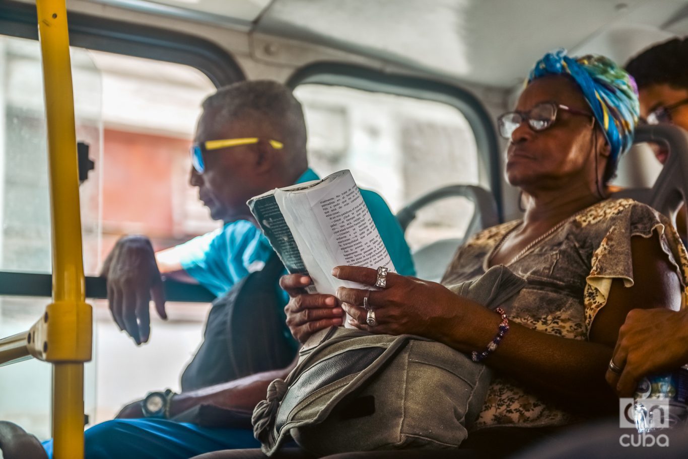 mujer negra lee en transporte público en cuba 2023
