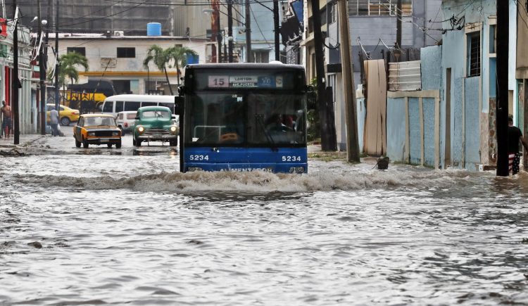 Un bus transita por una calle inundada, en La Habana debido al huracán Idalia. Foto: Ernesto Mastrascusa/EFE.