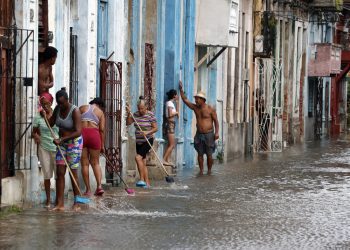 Residentes en La Habana sacan agua de sus casas en agosto de 2023 tras el paso de Idalia. Foto: Ernesto Mastrascusa.