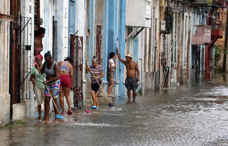 Residentes en La Habana sacan agua de sus casas en agosto de 2023 tras el paso de Idalia. Foto: Ernesto Mastrascusa.