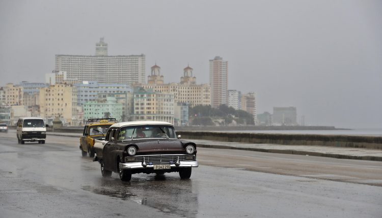 Vehículos bajo la lluvia que deja el huracán Idalia, en el Malecón en La Habana. Foto: Ernesto Mastrascusa/EFE.