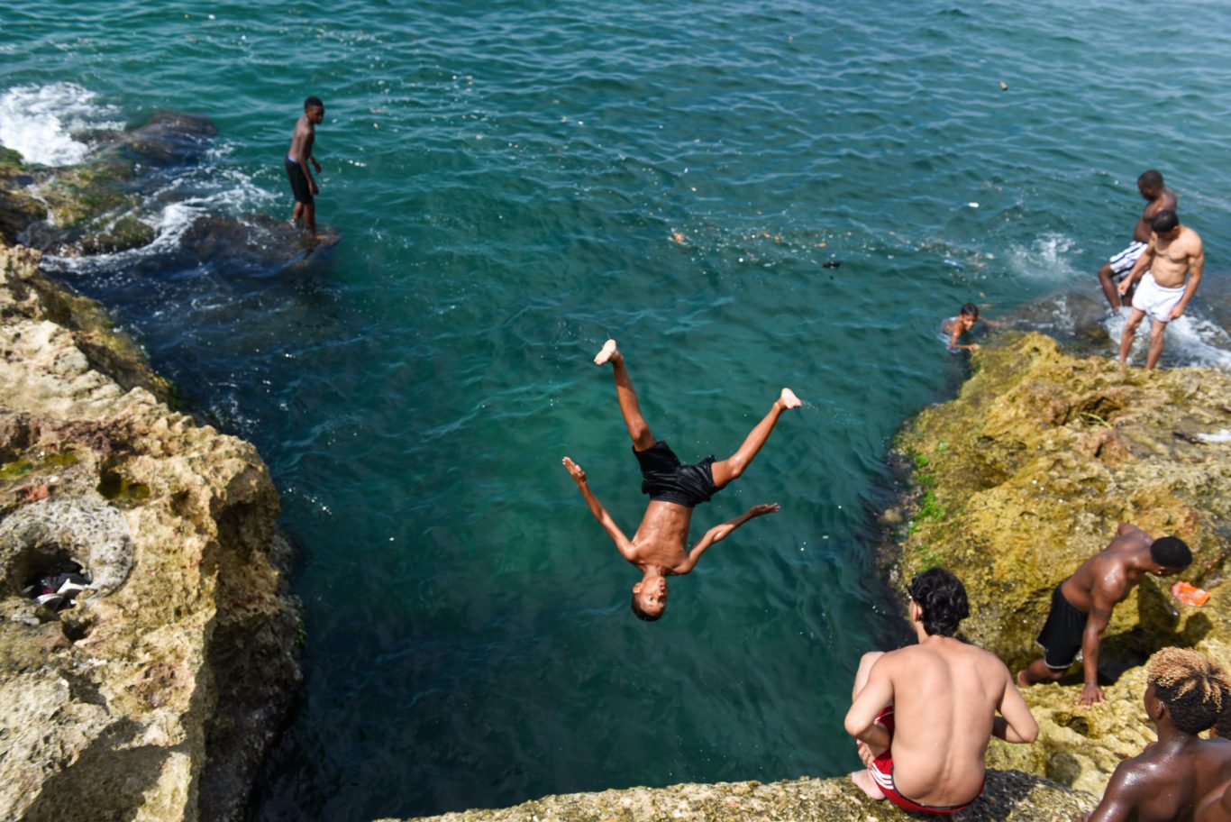 Adolescentes que se lanza al mar desde el muro en la famosa avenida habanera. Foto: Kaloian.