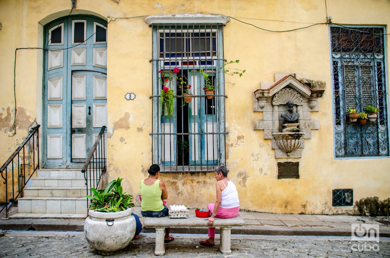 Dos vecinas sentadas en un banco en la loma del Ángel, donde hay un busto del escritor Cirilo Villaverde.