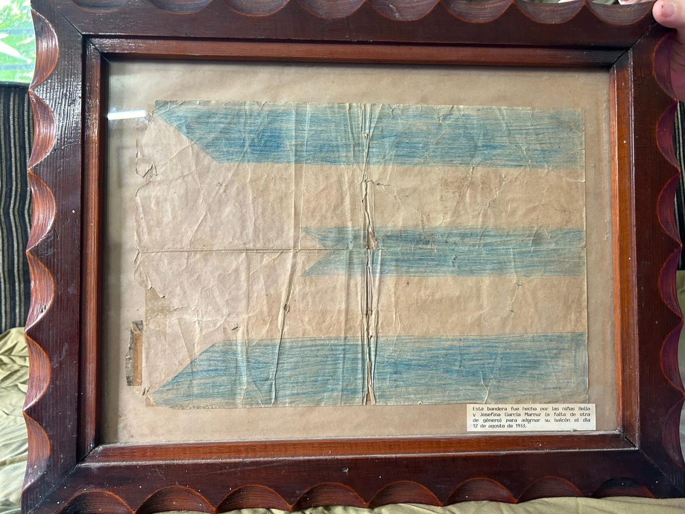 La banderita de papel de 1933 enmarcada por voluntad de Bella García Marruz y fotografiada en 2023. Foto: Cortesía de Josefina de Diego.