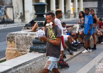 Un grupo de niños y adolescentes, detrás de un vendedor de cucuruchos de maní, en La Habana. Foto: Kaloian Santos Cabrera.