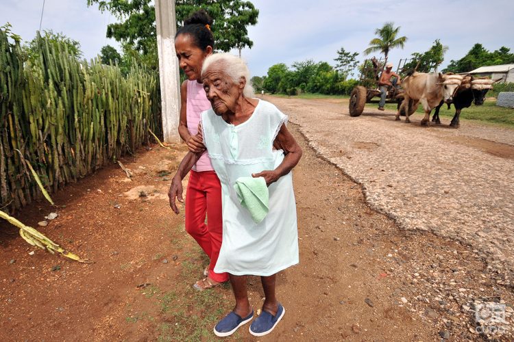 Una anciana es llevada por una familiar en una zona rural de Cuba. Foto: Alejandro Ernesto / Archivo.