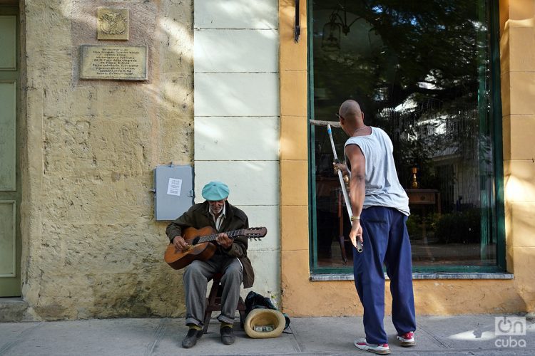 Un anciano toca para los turistas en La Habana Vieja. Foto: Alejandro Ernesto/Archivo.