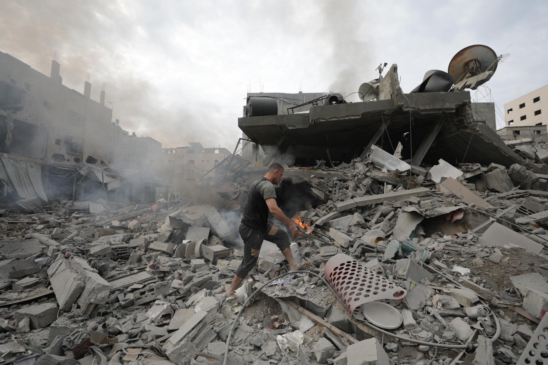 Un palestino inspecciona las ruinas del edificio destruido por los ataques aéreos israelís en Gaza este viernes. Más de 7000 palestinos han muerto por los ataques israelíes desde el 7 de octubre. Foto: EFE/ Mohammed Saber.