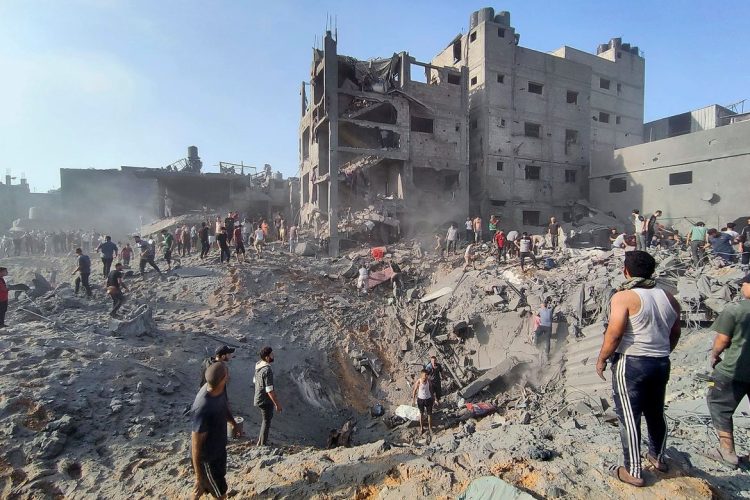 Palestinos inspeccionan los daños en los edificios destruidos por los ataques aéreos israelíes en el campo de refugiados de Jabalia. Foto: AP.