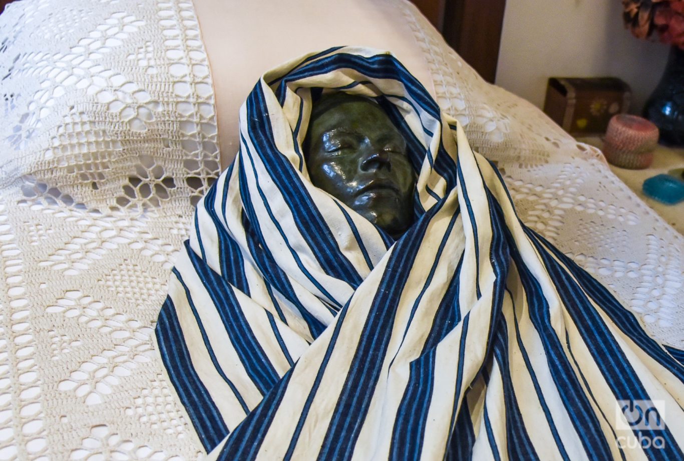 Máscara mortuoria de Frida Kahlo colocada sobre su cama, donde estuvo su cuerpo el día en que murió. Foto: Kaloian.
