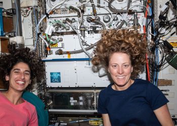 Jasmin Moghbeli y Loral O'Hara, ambas de la NASA, posan para un retrato frente al Laboratorio de Átomo Frío de la Estación Espacial Internacional. Foto: Nasa.