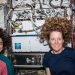 Jasmin Moghbeli y Loral O'Hara, ambas de la NASA, posan para un retrato frente al Laboratorio de Átomo Frío de la Estación Espacial Internacional. Foto: Nasa.