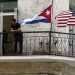 Cubanos conversan junto a banderas de Estados Unidos y Cuba, en La Habana. Foto: Ernesto Mastrascusa, tomada de El País.