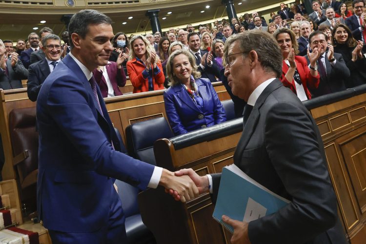 El líder del PP, Alberto Núñez Feijóo (d), felicita a Sánchez, al término de la segunda jornada del debate de investidura, este jueves. Foto: Javier Lizón/EFE.