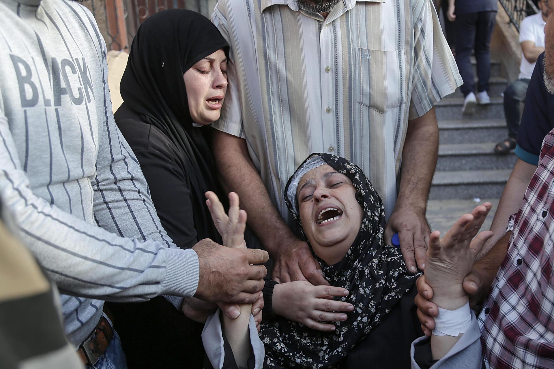 Palestinos en duelo mientras los cuerpos de sus familiares muertos por ataques israelíes llegan al hospital Naser en el campo de refugiados de Khan Younis. Gaza, octubre de 2023. Foto: EFE/EPA/Haitham Imad.