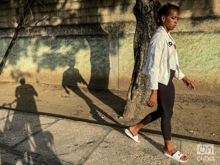 Mujer camina por una calle de Cuba. Foto: Kaloian.