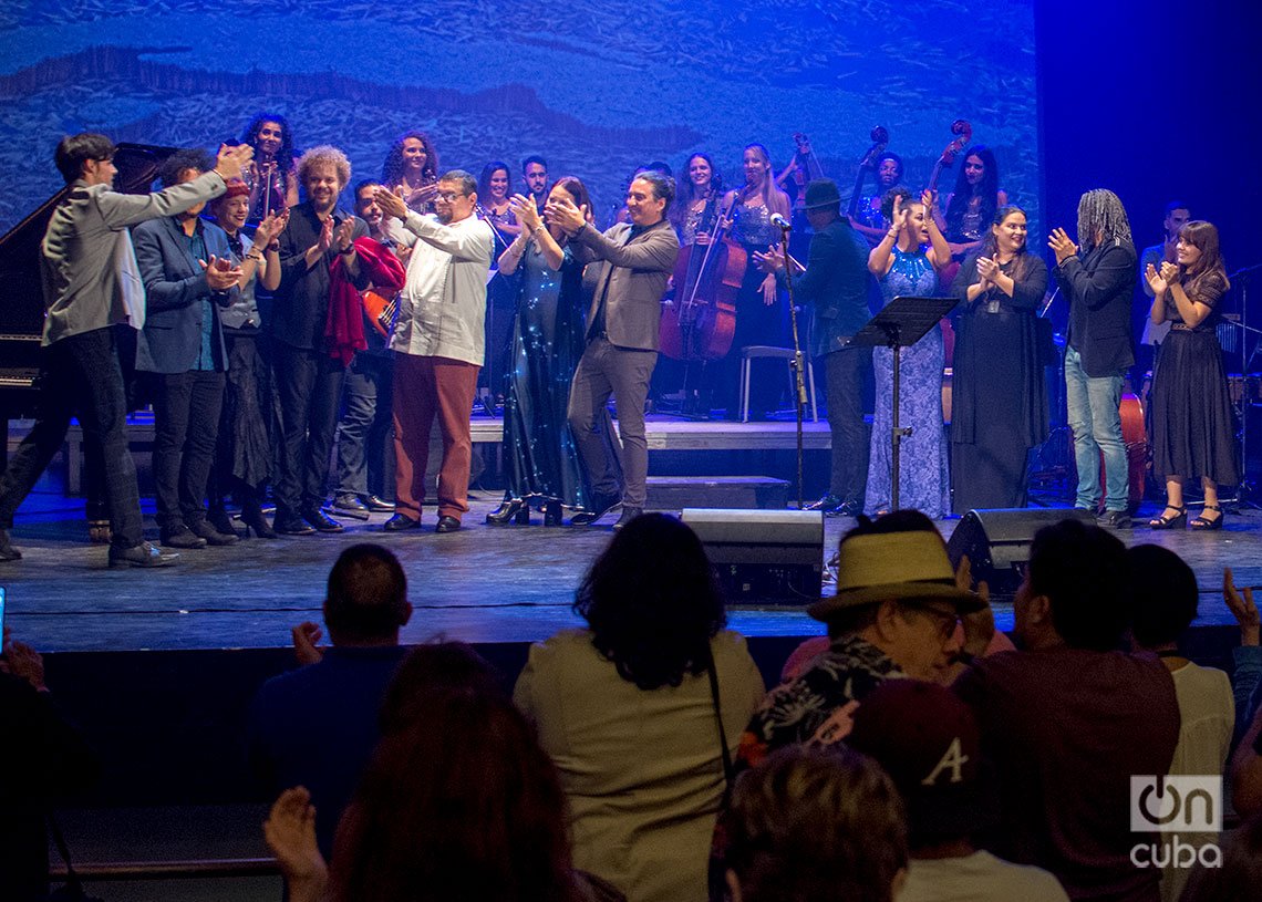 Músicos participantes en el concierto “Los Días de Gloria”, en el Teatro Martí, en La Habana, felicitan al pianista Rodrigo García al final de la presentación, mientras el público aplaude. Foto: Otmaro Rodríguez.