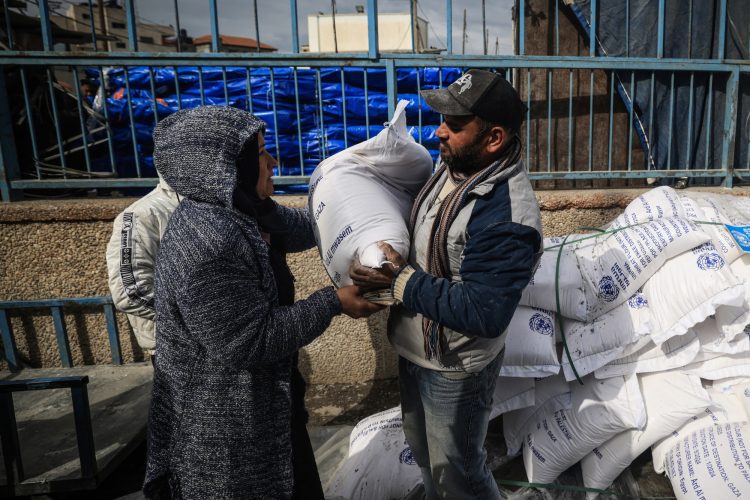 Palestinos desplazados reciben ayuda alimentaria en el centro de la Agencia de Naciones Unidas para los Refugiados de Palestina en Rafah el 28 de enero. Foto: AFP.