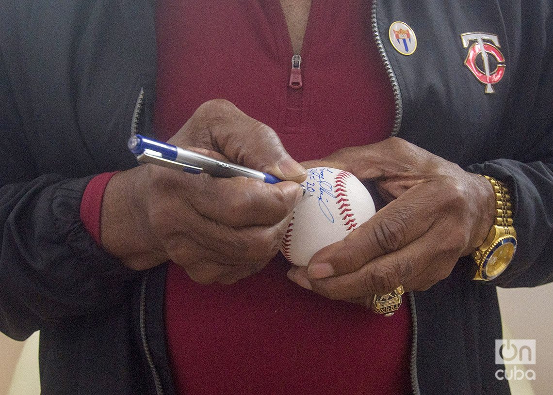 Tony Oliva firma una pelota de béisbol en el Estadio Latinoamericano de La Habana. Foto: Otmaro Rodríguez. 