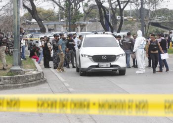 Policías investigan el vehículo con impactos de bala en el que se encontraba el fiscal César Suárez al ser asesinado. Foto: Jonathan Miranda/EFE.
