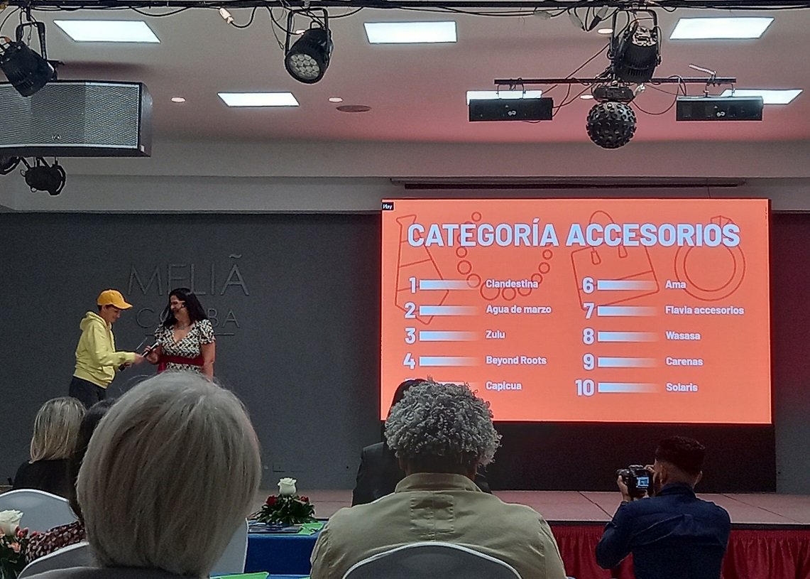 Idania del Río (der), de Clandestina, recibe el premio que reconoce a la empresa como líder de notoriedad entre las marcas de accesorios de moda, a partir de los resultados del  segundo Ranking de Notoriedad de Marcas Privadas en Cuba. Foto: Foto: OnCuba.