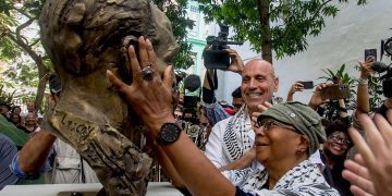 La escritora estadounidense Alice Walker toca el busto de bronce del poeta Langston Hughes, en el Patio de la Poesía, en La Habana. Foto: Otmaro Rodríguez.